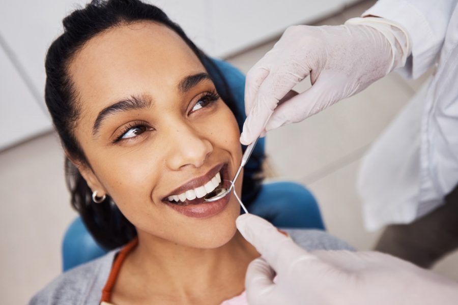 Hands, woman or dentist with tools for dental procedure, clean teeth or cavity removal in clinic. Mirror, excavator or patient with medical orthodontist for gum care, oral hygiene or smile for health