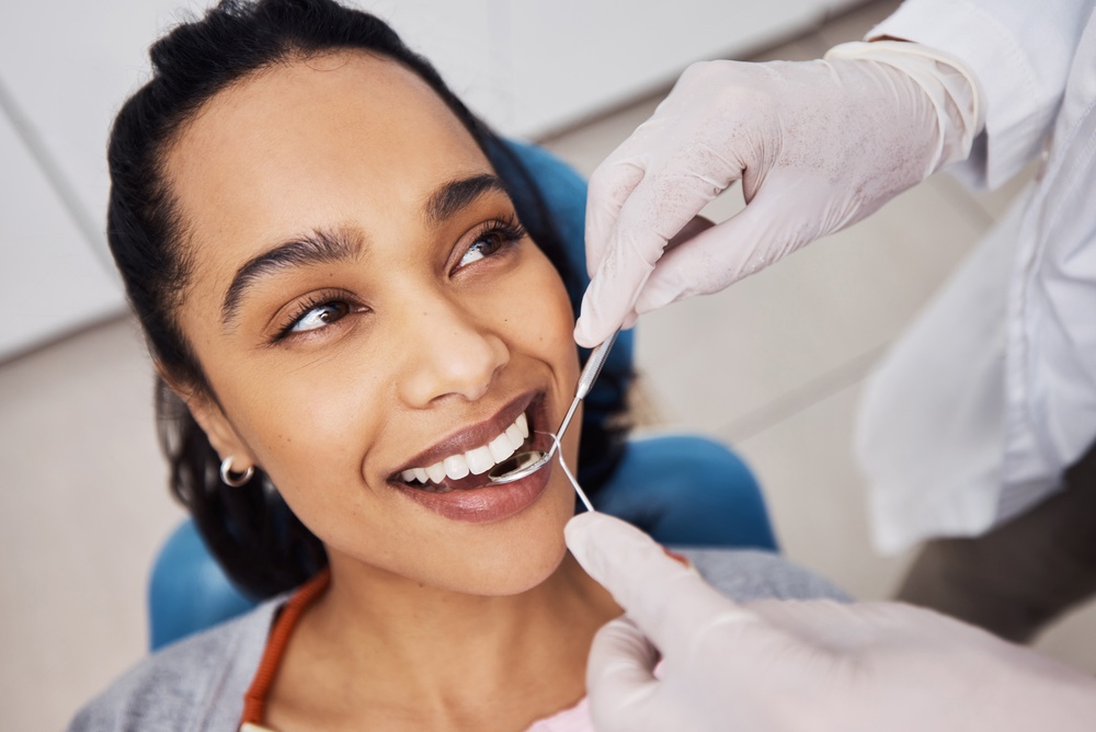 Hands, woman or dentist with tools for dental procedure, clean teeth or cavity removal in clinic. Mirror, excavator or patient with medical orthodontist for gum care, oral hygiene or smile for health