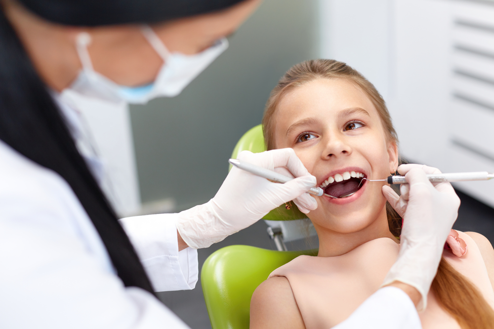 Gentle Pediatric Dental Exam for Children – Pediatric A smiling child receiving a gentle dental examination, highlighting comfort, trust, and preventive care in pediatric dentistry – Pediatric