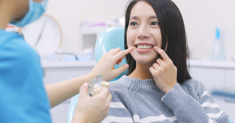 A patient smiling while discussing her teeth with a dental professional, highlighting personalized care and routine services in general dentistry – General Dentistry