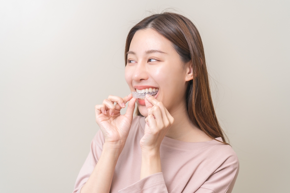 A patient gently placing Invisalign clear aligners, highlighting comfortable, removable orthodontic treatment for discreet smile correction – Invisalign in Rancho Mirage