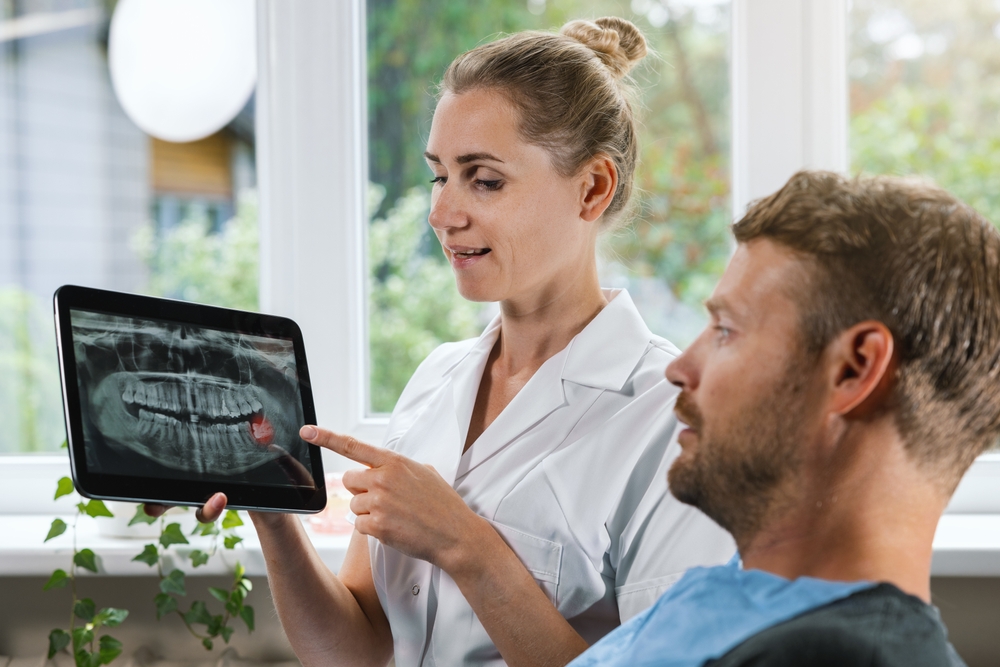 A dentist reviewing a digital dental X-ray with a patient, emphasizing diagnosis, education, and comprehensive care in general dentistry – General Dentistry