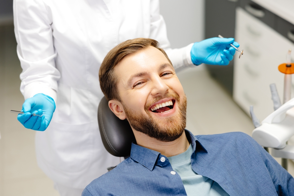 Confident Smile During Cosmetic Dentistry Procedure – Cosmetic Dentistry A happy patient laughing during a cosmetic dental procedure, emphasizing comfort, trust, and expert cosmetic dentistry care – Cosmetic Dentistry