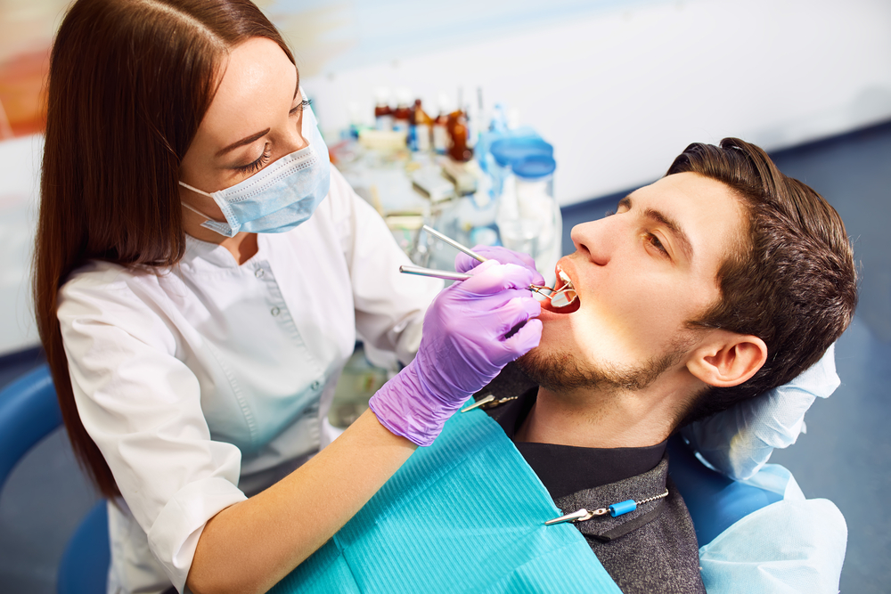 Precise Dental Restoration Procedure in Progress – Restorative Dentistry A dentist carefully performing a restorative dental procedure, showcasing precision care used to repair and protect damaged teeth – Restorative Dentistry